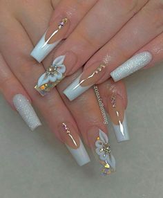 a woman's hands with white and gold nail designs