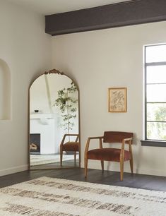 a chair sitting in front of a large mirror