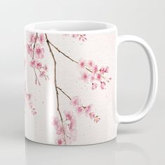 a white coffee mug with pink flowers on it