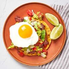 an orange plate topped with two tacos and an egg