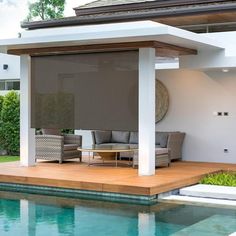 an outdoor living area next to a swimming pool