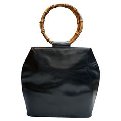 This vintage GUCCI top handle shoulder tote bag is crafted of soft calfskin leather in black featuring two massive bamboo ring handles. Top magnetic snap closure opens to a new interior in black featuring a zippered pocket. Made in Italy. Measures approximately 15.5 x 14 x 4.25 inches Handle diameter 7 inches. Comes with dust bag. Condition - Generally in very good vintage condition with minor signs of wear. Interior fully re-lined Outside: Minor marks on leather Inside: Interior fully re-lined and fit to use Smell: No odor Bamboo Ring, Gucci Top, Ring Handle, Gucci Leather, Shoulder Bag Black, Shoulder Tote Bag, Shoulder Tote, Fashion Handbags, Vintage Gucci