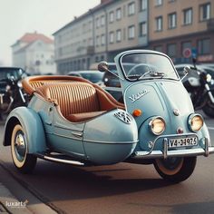 an old car is parked on the side of the road in front of other cars