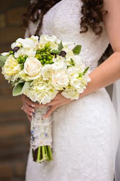 a bride holding a bouquet of white flowers