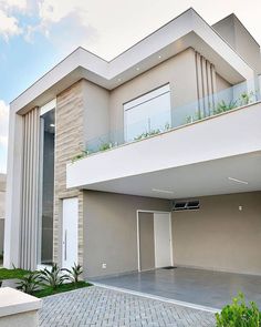 a modern house with two balconies on the second floor