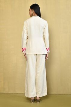 Cream top with a side tie-up and floral embroidered sleeves. Paired with a matching pant with floral embroidery. - Aza Fashions Embroidered Linen Long Sleeve Sets, Spring Floral Embroidered Long Sleeve Pant Set, Spring Floral Embroidery Long Sleeve Pant Set, Traditional Linen Workwear Sets, Elegant Cotton Sets With Embroidered Cuffs, Traditional Linen Sets For Workwear, Spring Cotton Sets With Embroidered Sleeves, Fitted Floral Embroidered Pant Set With Long Sleeves, Fitted Pant Set With Floral Embroidery