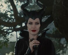 maleficent in the movie maleficent is wearing horns and holding a snake