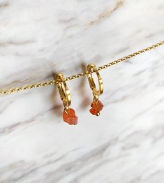 These earrings are composed of two tiny raw carnelian gemstones, 14K gold plated earwires. Carnelian is belived to enhance creativity and self esteem, among other properties. It also makes a very unique gift! Earring length: 1 inches / 2.5 cm ❈ We send all our items with registered mail. ❉ Due to the organic nature of stones, there might be a slight variation in colour, size and shape. ✺ All items come packaged in a quality velvet pouch ready for gift giving. ✽ If you want to make a special orde Minimalist Gold Huggie Earrings With Gemstone, Minimalist Gold Hoop Earrings With Gemstone, Minimalist Amber Earrings For Gift, Gold Dainty Gemstone Hoop Earrings, Dainty Gold Hoop Earrings With Gemstone, Minimalist Orange Earrings For Everyday, Orange Minimalist Earrings For Everyday, Everyday Minimalist Orange Earrings, Gold Carnelian Dangle Earrings