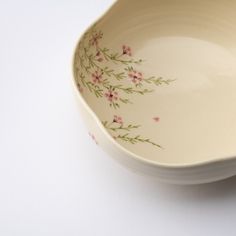 a white bowl with pink flowers painted on it