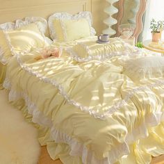 the bed is made with yellow ruffles and white pillows on top of it