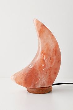 an orange stone lamp sitting on top of a white table next to a black cord