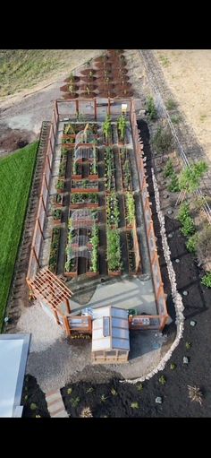 an aerial view of a vegetable garden with lots of plants in the center and several rows of raised beds on each side