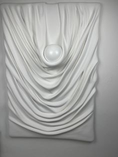 a white square sculpture with a circular object in the center