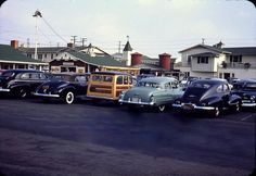 several old cars parked in a parking lot