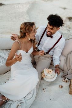 a man and woman sitting next to each other in front of a cake