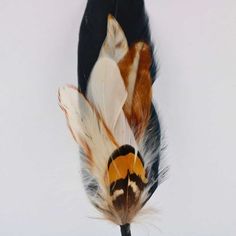 an orange, black and white feather is attached to a hook