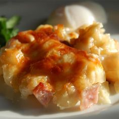 a white plate topped with macaroni and cheese covered in sauce