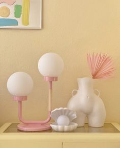 three white and pink vases sitting on top of a table