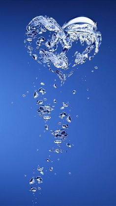 a heart shaped object floating in the water with bubbles on it's side and blue background