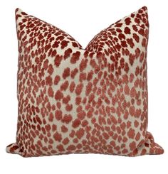 a red and white leopard print pillow on a white background