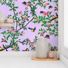 a pink wallpaper with birds and flowers on it in the corner of a room