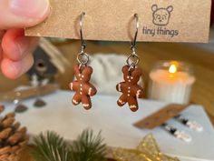 a pair of tiny brown teddy bears dangling from earrings