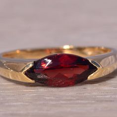 This Stunning Piece, Known As The Crimson Marquise Ring, Features A Captivating Marquise-Cut Garnet At Its Center Set East To West. The Rich, Deep Red Garnet Is Elegantly Set In A 14 Karat Yellow Gold Band, Designed With Sleek, Modern Lines That Add A Touch Of Sophistication. The Ring Is Currently A Finger Size 7 But Can Be Adjusted To Any Finger Size For An Additional Charge Upon Request, Ensuring A Perfect Fit. Yellow Gold Color, Marquise Ring, Garnet Ring, Garnet Rings, Marquise Cut, Red Garnet, Gold Band, Womens Jewelry Rings, Deep Red