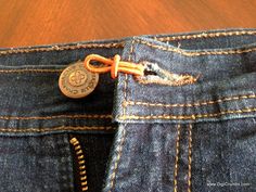 there is a button in the back pocket of a pair of blue jeans with zippers