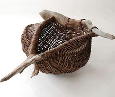 a wicker basket with an animal's head sticking out of the handle, on a white background