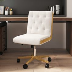 a white office chair sitting in front of a wooden desk with books on the shelves