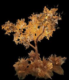 a lighted tree is shown with leaves and flowers on the bottom, in front of a black background