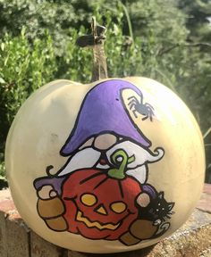 a painted pumpkin sitting on top of a brick wall