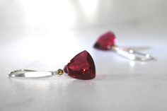 "Gorgeous red trillion of AAA quartz with a sparkle of warm gold for simply stunning earrings. Drops of pure, gorgeous red with just an ever so slight tinge of pink! So pretty and delicate and so luscious! Red ruby quartz in a trillion cut accented with a tiny gold hematite, so perfect for that simple touch of elegance. A sterling silver ear wire has been slightly hammered and finished into a modern, sleek contemporary earwire. These are perfect pops of gorgeous color! Quartz Trillions are 12mm Red Gemstone Earrings For Valentine's Day, Party Red Gemstone Earrings, Red Faceted Dangle Earrings, Modern Red Teardrop Jewelry, Red Faceted Drop Earrings, Red Ruby Drop Earrings, Red Faceted Earrings For Anniversary, Red Faceted Earrings For Formal Occasions, Modern Red Earrings For Party