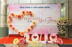 a large sign with flowers in the shape of a heart is displayed at an event