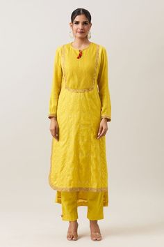 Mustard yellow three fourth sleeves high low panelled kurta in banarasi silk base with pintucked yoke, sleeves and sequin marodi fleur embroidery on the borders. Paired with a thread tassel embellished straight pant and lace border embellished seersucker pattern dupatta. - Aza Fashions Gold Long Sleeve Slub Silk Kurta, Yellow Chikankari Embroidered Straight Kurta, Gold Slub Silk Salwar Kameez With Long Sleeves, Fitted Yellow Traditional Wear For Transitional Season, Fitted Yellow Traditional Wear, Chanderi Long Sleeve Kurta With Yoke, Transitional Season Yellow Salwar Kameez With Chikankari Embroidery, Transitional Yellow Chikankari Embroidery Salwar Kameez, Yellow Salwar Kameez With Chikankari Embroidery For Transitional Season