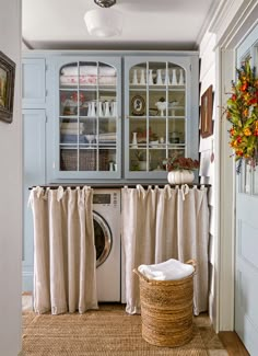 a washer and dryer sitting in a room next to a cabinet with glass doors