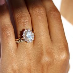 a woman's hand with a diamond ring on top of her finger and an engagement band