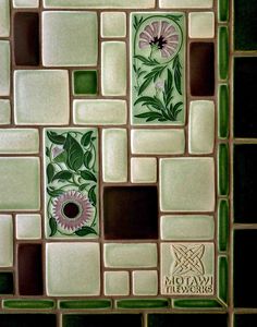 an artistic tile design with flowers and leaves in green, brown, and white colors