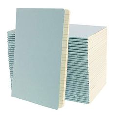 a stack of notebooks sitting next to each other on top of a white surface