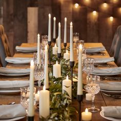 a long table with candles on it and place settings in front of the dinner table