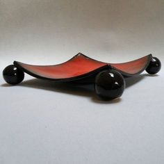 a red and black object sitting on top of a white table