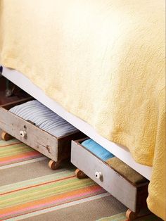 a bed with two drawers underneath it and a yellow bedspread on the other side