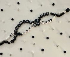 a black and white beaded necklace with the words love you written on it, surrounded by beads