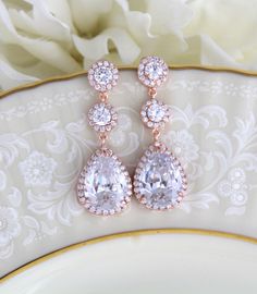 "Swarovski Pure Brilliance Cubic Zirconia rose gold bridal earrings feature pave framed rounds which dangle into a brilliant pear-shaped drop. These beautiful earrings are created in genuine Rose Gold plating and they're sure to look glamorous on brides looking for blush gold jewelry to accessorize their wedding gowns. Earrings measure 1-7/8\" Matching necklace: https://www.etsy.com/listing/273127374/bridal-backdrop-necklace-rose-gold-back?ref=shop_home_active_1 Matching bracelet: https://www.et Wedding Bridal Earrings In Rose Gold With Halo Design, Rose Gold Halo Bridal Earrings For Wedding, Rose Gold Bridal Drop Earrings With Elegant Design, Glamorous Rose Gold Dangle Bridal Earrings, Dazzling Rose Gold Wedding Earrings, Dazzling Rose Gold Earrings For Wedding, Dazzling Rose Gold Bridal Earrings, Rose Gold Drop Bridal Earrings For Formal Occasions, Rose Gold Teardrop Halo Jewelry