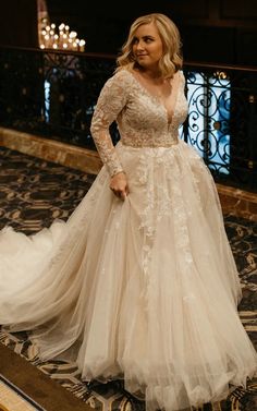 a woman in a wedding dress standing on the floor