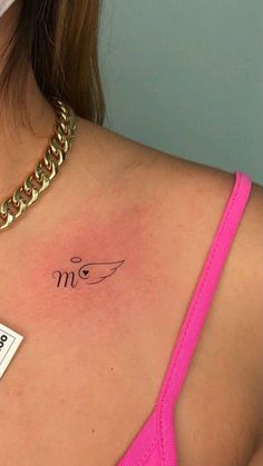 a woman with a tattoo on her chest has a name tag in front of her shoulder