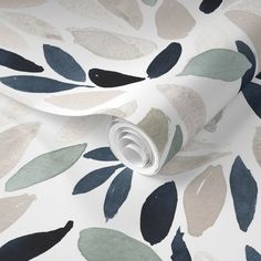 a white wallpaper with blue and green leaves on the back ground, next to a roll of toilet paper