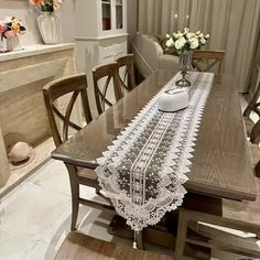 a dining room table and chairs in front of a window with white flowers on it