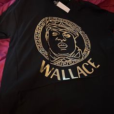 Get Your Fashion Notorious Biggie Wallace Shirt Comes In All Various Size Black Only With The Gold Tone. Trendy Gold Tops With Graphic Print, Gold Letter Print Top For Streetwear, Gold Tops With Logo Print For Streetwear, Gold Tops With Letter Print For Streetwear, Gold Casual Tops For Streetwear, Casual Gold Tops For Streetwear, Notorious Biggie, Peace Sign Shirts, Lacoste Shirt