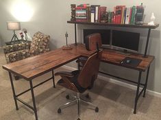 a computer desk with a laptop on it in front of a book shelf and chair